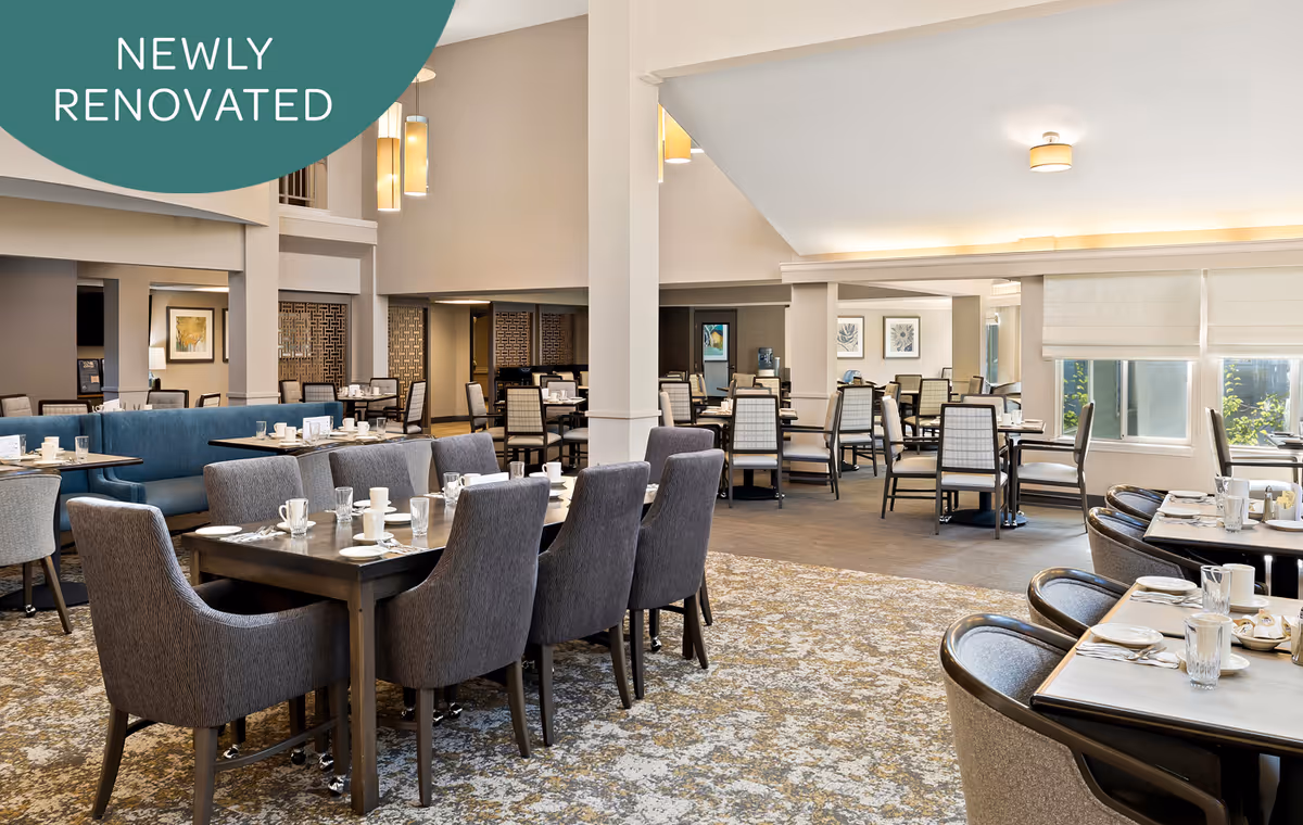 Spacious, newly renovated dining room with multiple set tables, upholstered chairs, and large windows.