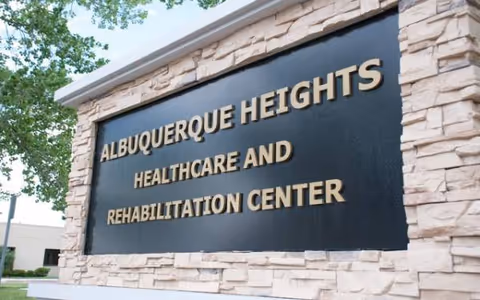 A stone-framed sign reads Albuquerque Heights Healthcare and Rehabilitation Center.