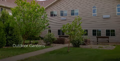 Copper Creek Senior Living exterior with trees and an outdoor garden area.