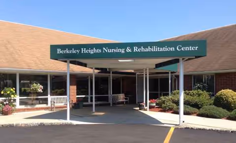 Front entrance of Berkeley Heights Nursing & Rehabilitation Center with benches and plants.