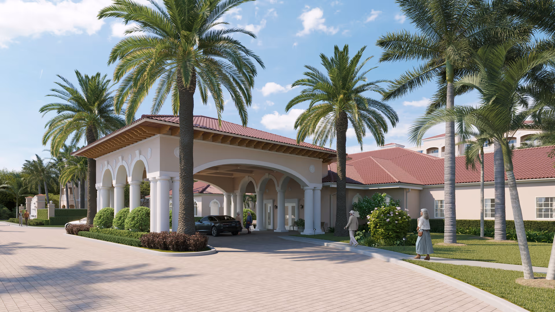 Mediterranean-style assisted living building front with a covered porte-cochère, palm trees, a parked car, and people on a sunny day.