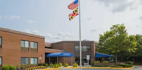 Future Care Northpoint exterior with brick walls, blue canopies, and flag at entrance.