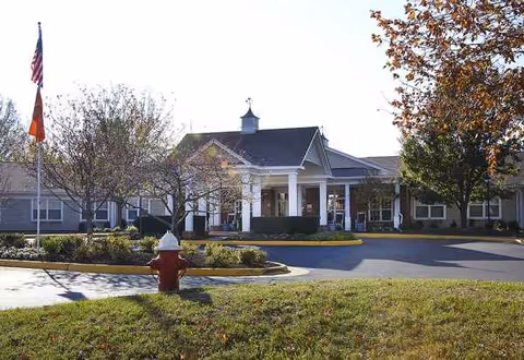 Exterior view of Sunrise at Huntcliff Summit I front entrance with flags and driveway.