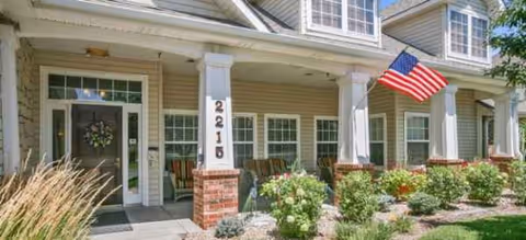 Exterior view of Brookdale Brighton senior living facility with a front porch and flag.