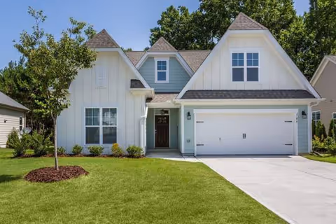 White two-story building with a large garage and well-kept front lawn.