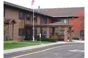 Exterior view of St Marks Terrace with entrance canopy, flagpoles, and parking.