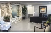 Reception lobby with stone accent wall, seating area, and a dark front desk.