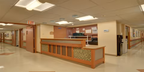 Interior hallway of a senior rehab facility with a reception desk.