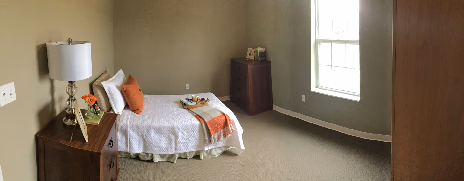 Furnished bedroom with a single bed, bedside tables, lamp and a window.
