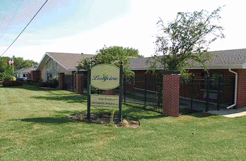 Exterior view of Azria Health Longview facility with sign near brick entrance.