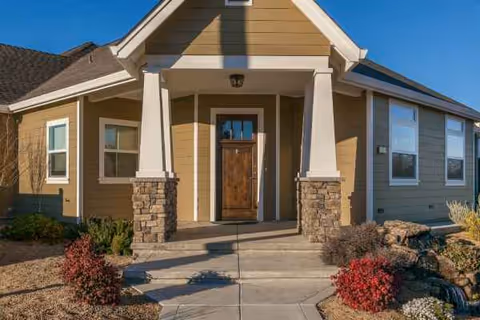 Front exterior view of Almond Blossom Assisted Living facility entrance with walkway and landscaping.