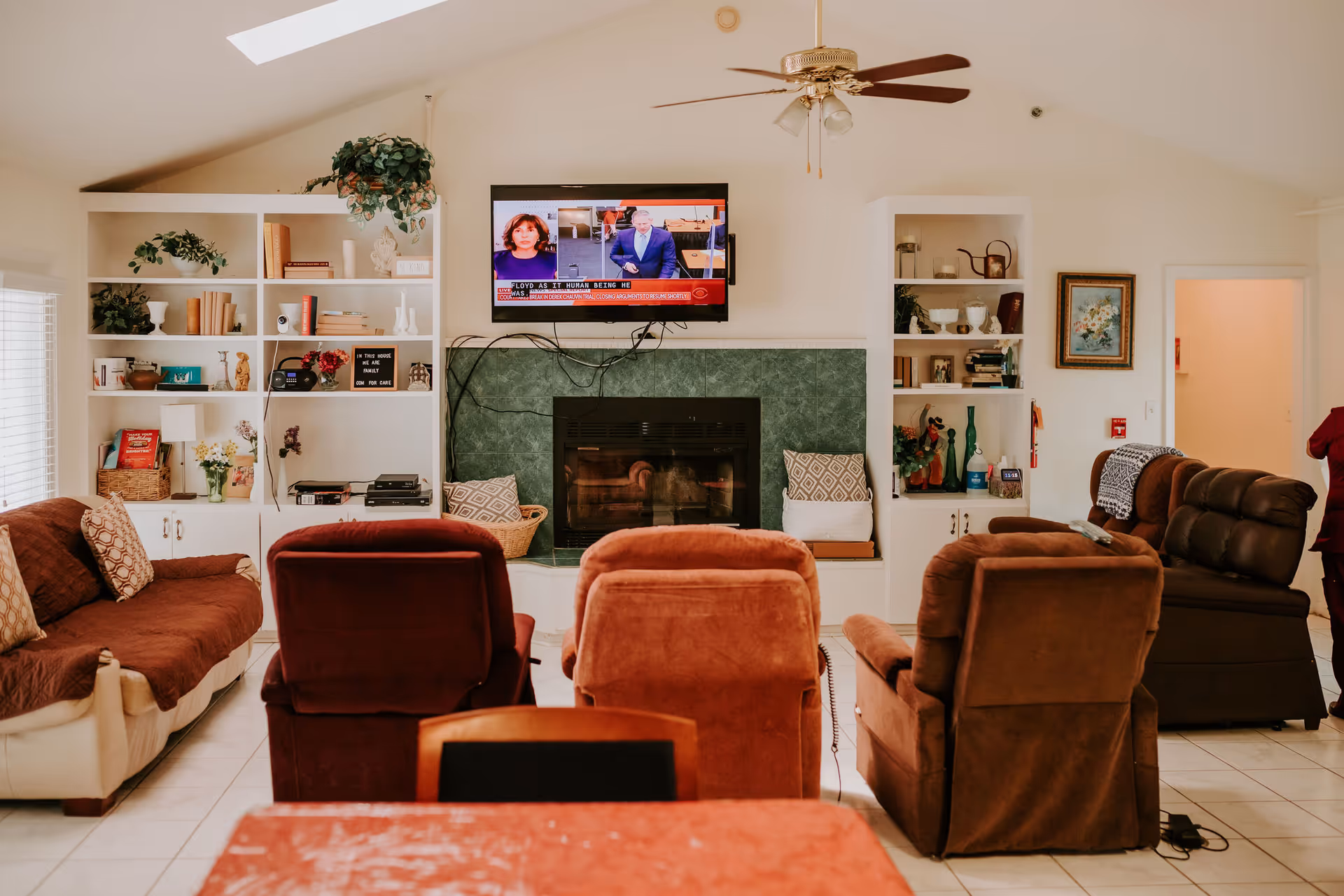 Cozy living room with multiple chairs facing a fireplace and mounted TV.