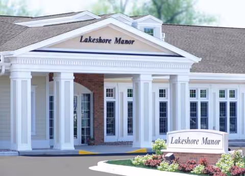 Front view of Lakeshore Manor showing its columned entrance and landscaped sign.
