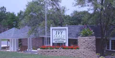 Exterior view of a senior care center entrance with a stone planter and sign