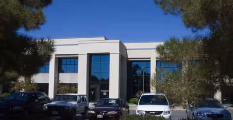 Front view of Coalinga Regional Medical Center building with several parked cars in front.
