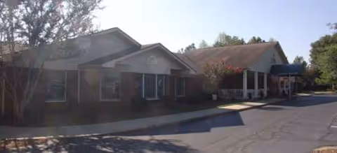 Exterior view of a brick, single-story senior living facility with covered entrances.