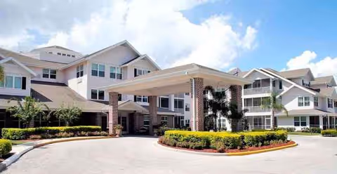 Exterior view of Desoto Beach Club Sky Active Living with a covered entrance and landscaped grounds.