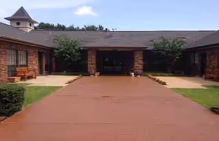 Brick single-story Independence Village exterior with a red walkway leading to the entrance.