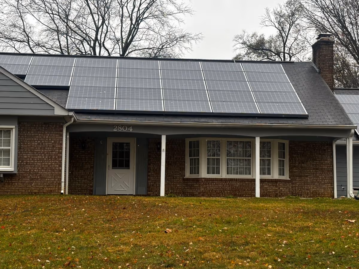 Front exterior of a single-story brick house with large solar panels on the roof and the address '2804' above the porch.