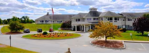 Exterior view of Sterling Village senior living facility with circular driveway and landscaped grounds.