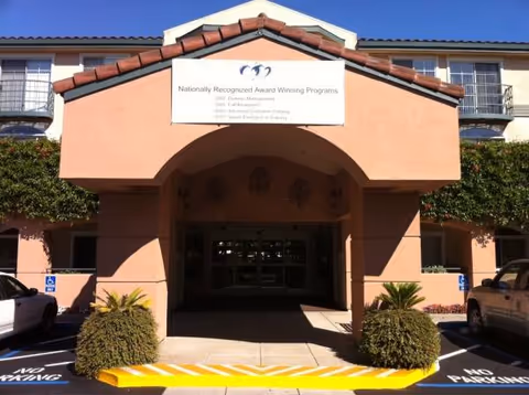 Front view of Carlton Senior Living Fremont entrance with archway and sign.