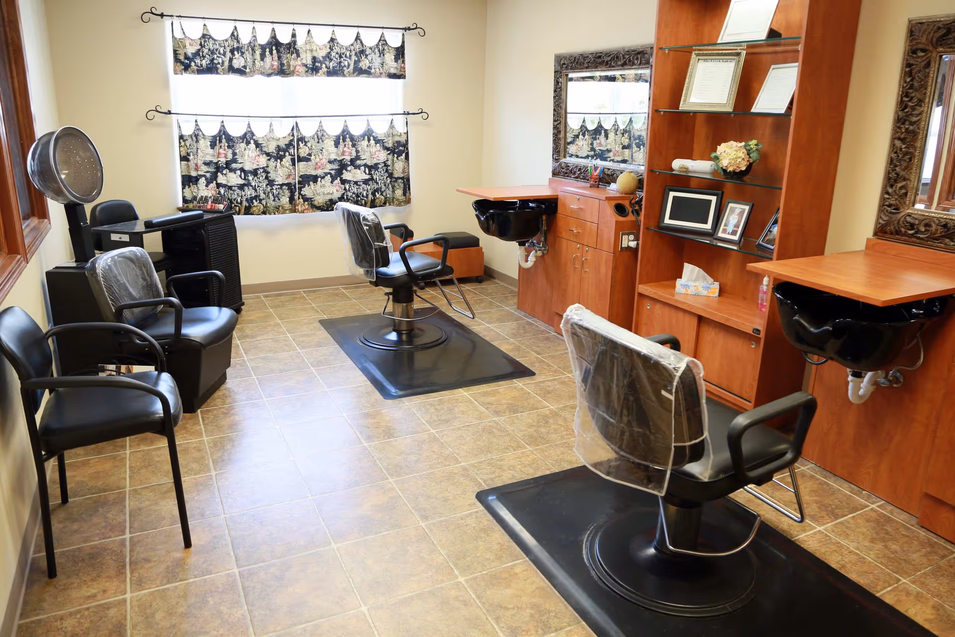 Hair salon room with styling chairs, shampoo sinks, mirrors, and shelving.