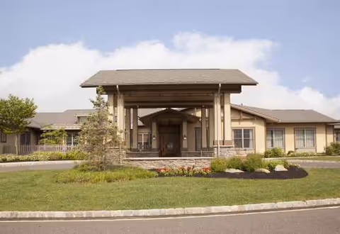 Exterior view of Sunrise of Jackson with a covered entrance and landscaped front yard.