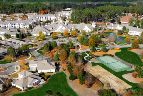 Aerial view of Belle Meade Retirement Community with buildings, greenery, and a tennis court.