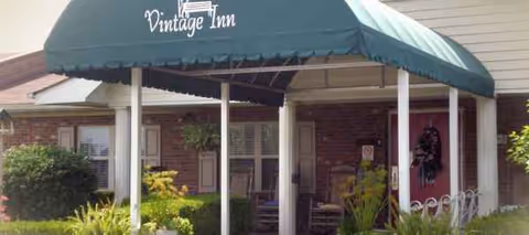 Exterior view of Vintage Inn Retirement Community entrance with a green canopy.