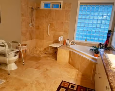 Accessible bathroom in a senior care facility with shower, tub, toilet, and grab bars.