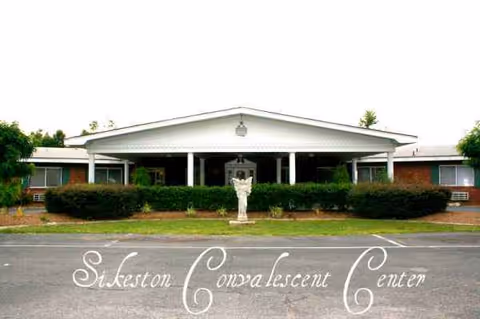 Front view of a single-story convalescent center with a covered entrance and hedges.