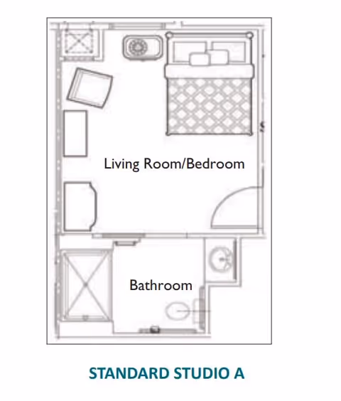 Floor plan of a standard studio apartment labeled 'Standard Studio A' showing a combined living room and bedroom area with a bed, chair, and sink, and a separate bathroom with a shower, toilet, and sink.