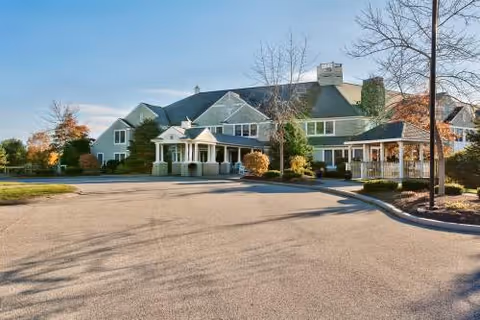 Front exterior of The Landing at Cape Elizabeth with driveway and trees.
