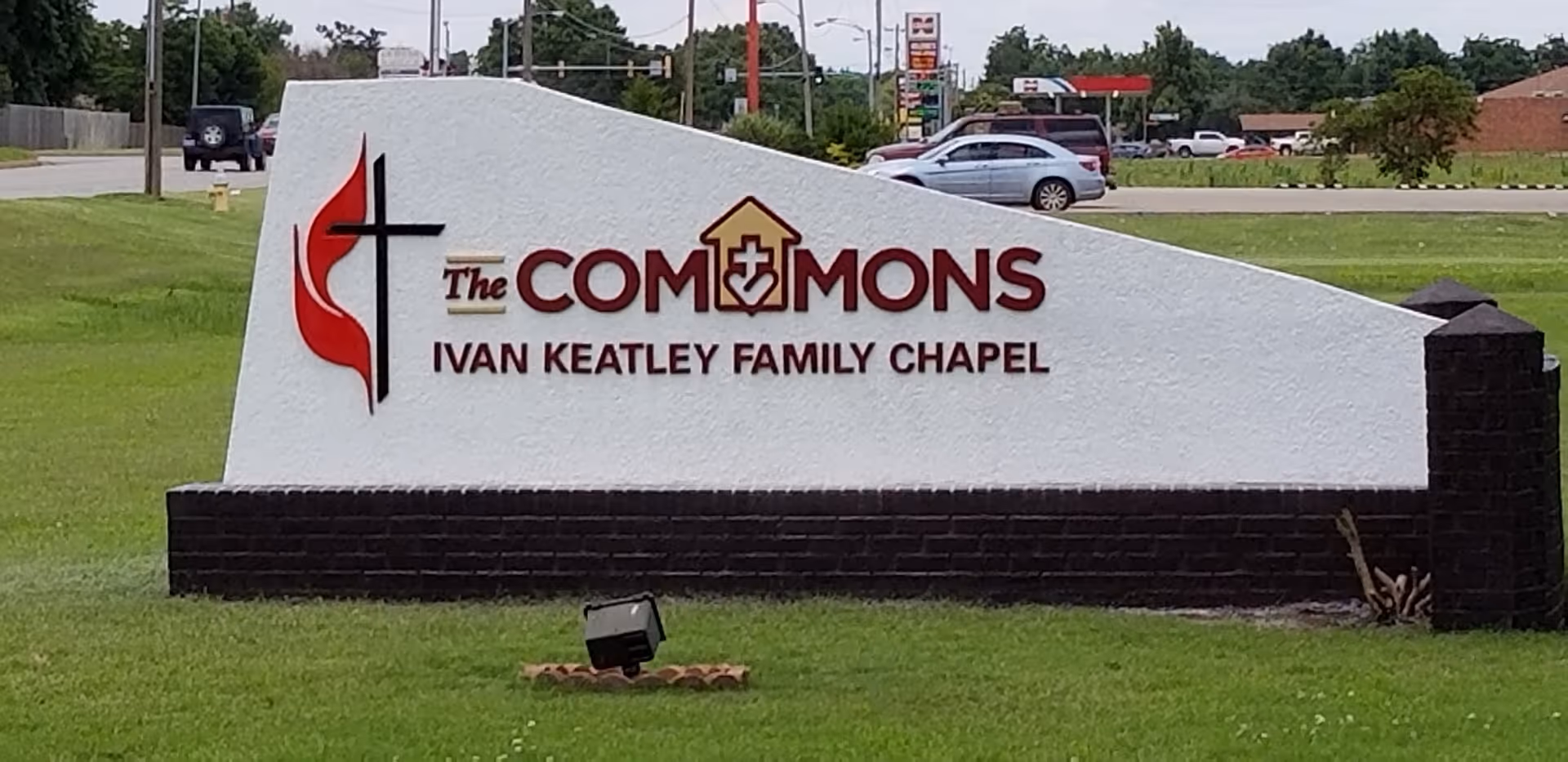Sign for 'The Commons' senior living facility featuring the name and chapel.