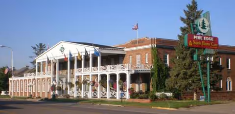 Exterior view of a brick senior living facility with a covered front porch.