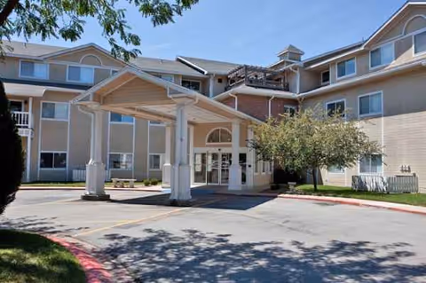 Exterior view of a senior living facility entrance with a covered drop-off area.