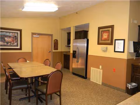 Senior living facility dining area with a table, chairs, and wall art.