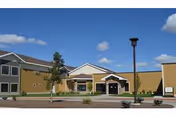 Exterior view of a senior living facility with parking and a main entrance.