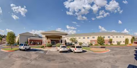 Front exterior view of Royal Estates of El Paso with a covered entrance and parked cars.