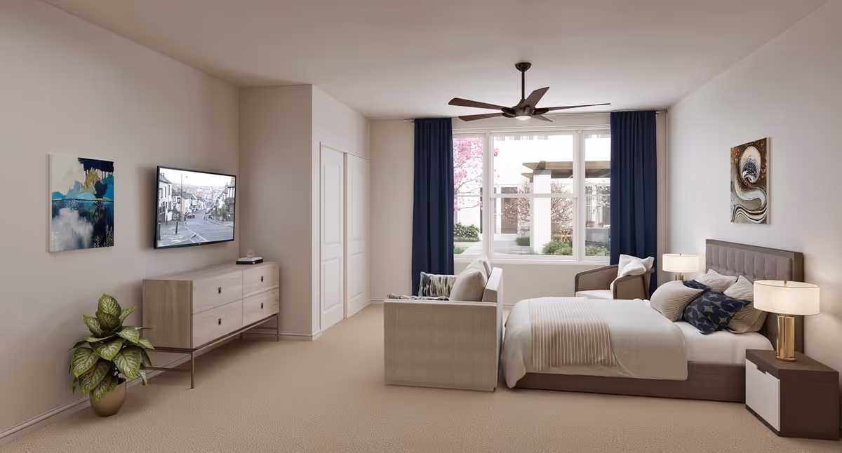 Bright, spacious bedroom with a bed, sofa and dresser facing a wall-mounted TV and a large window.