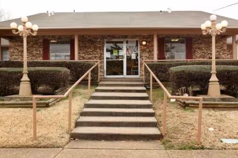 Front view of Focused Care at Linden facility entrance with stairs and shrubs.