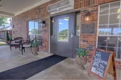 The Brookridge Cove Rehab & Care entrance with brick exterior, glass doors, benches, and potted plants.