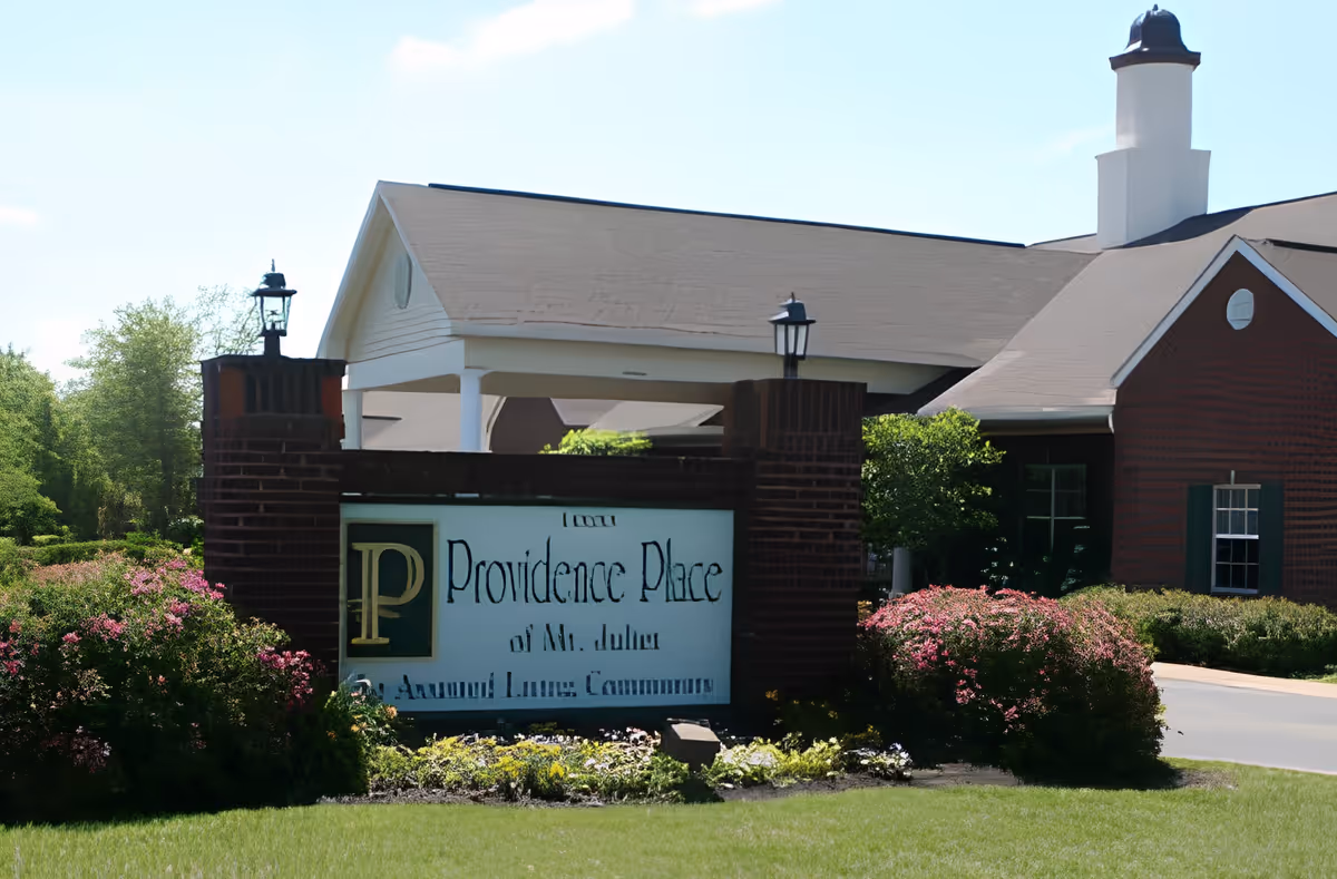 Entrance sign and front facade of Providence Place of Mt. Juliet senior living community with landscaped bushes and lawn.