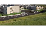 Exterior view of Vestal Park Rehabilitation and Nursing Center with beige buildings, parking, and grassy hills.