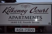Outdoor sign reading "Kilkenny Court Apartments" with address and phone number.