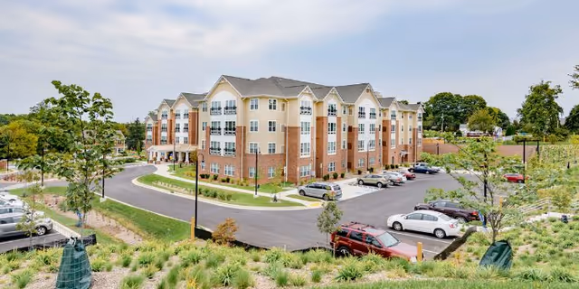 Victory Haven Senior Apartments building with brick facade, parking lot, and landscaped surroundings.