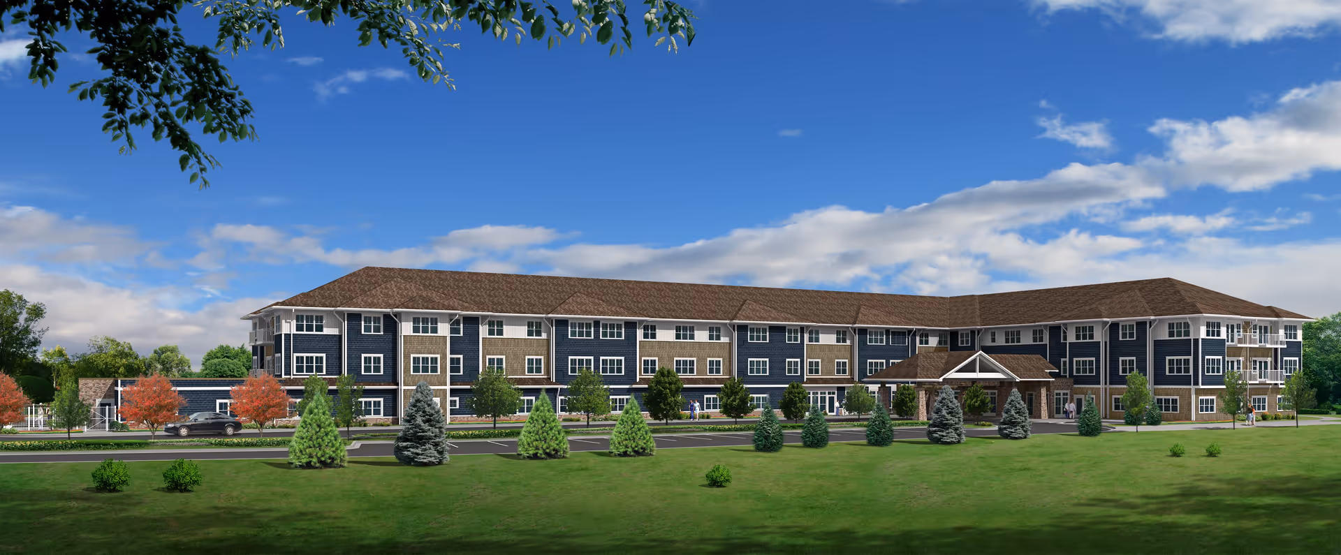 Exterior view of a large, three-story senior living facility building with a brown roof and blue and beige siding. The building is surrounded by a well-maintained lawn, small trees, and shrubs under a partly cloudy blue sky.