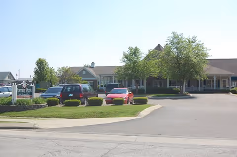 Front exterior of the Morning Pointe of Franklin senior living building with parked cars and landscaped driveway.