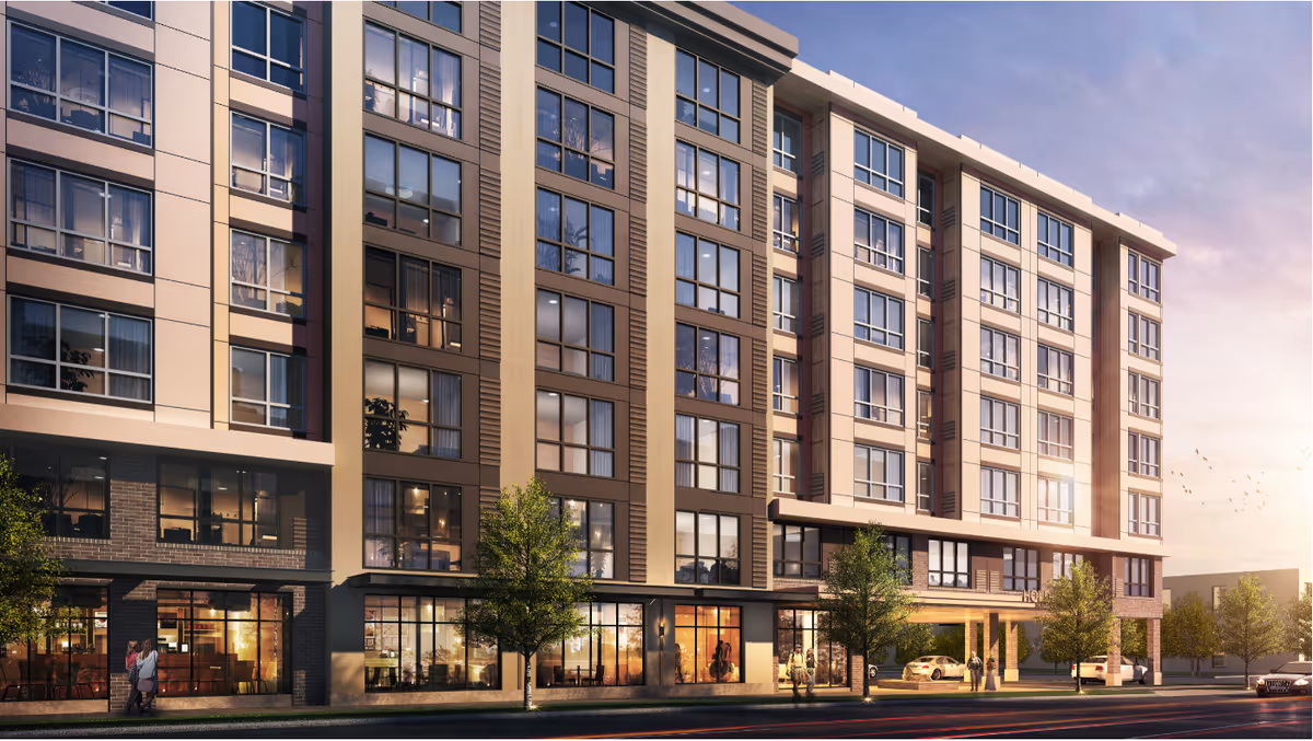 Modern multi-story senior living building exterior with large windows and storefronts along a street.
