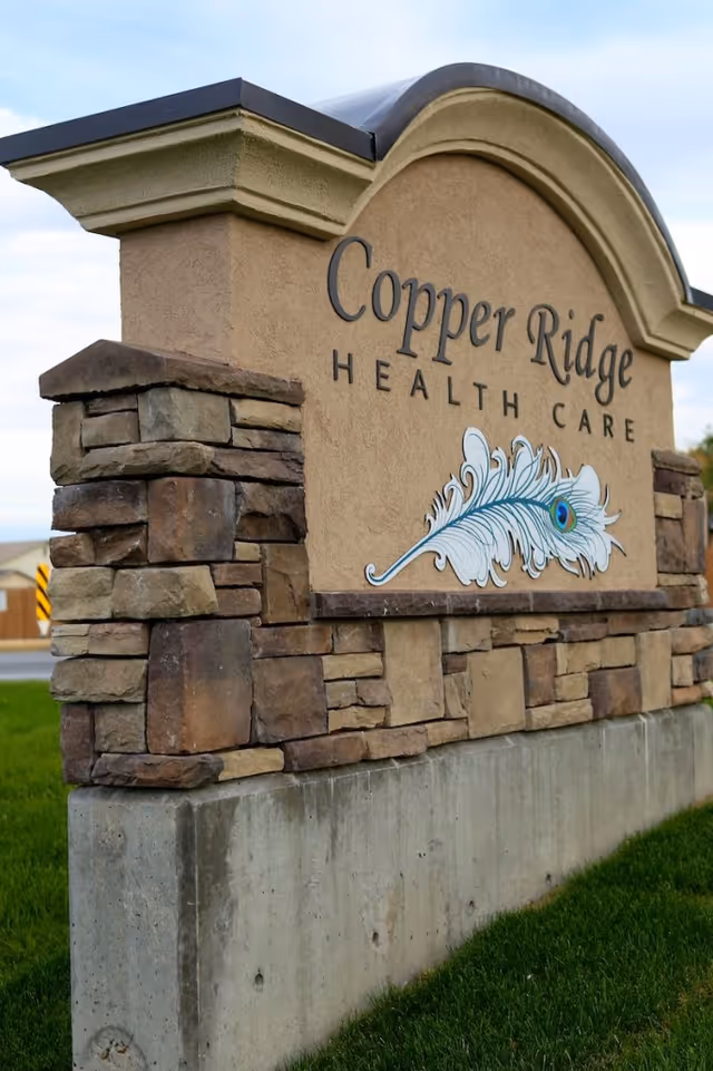 Entrance stone sign for Copper Ridge Health Care featuring a decorative feather emblem.